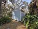 Blue storage shed with white trim in a garden setting at 1401 Cr 449, Lake Panasoffkee, FL 33538
