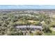 An aerial view of an apartment building with parking, surrounded by trees and offering a distant town view at 150 El Dorado # 101, Winter Haven, FL 33884