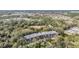 Aerial view of an apartment building in a wooded setting, showing parking and distant suburban views at 150 El Dorado # 101, Winter Haven, FL 33884