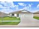 Single-story home with a two-car garage and landscaped lawn at 1125 Michelangelo Ln, Winter Haven, FL 33884