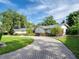 Landscaped yard with brick paver driveway leading to a single-story house at 1400 S Pennsylvania Ave, Winter Park, FL 32789