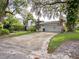 Single-car garage with a long driveway, surrounded by mature trees and landscaping at 1400 S Pennsylvania Ave, Winter Park, FL 32789