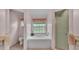 A well-lit bathroom featuring a garden tub, shower, toilet, and neutral tile flooring at 4064 River Crest Cir, Leesburg, FL 34748