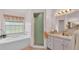 Bright bathroom features a tub under a window, vanity with ample cabinet space and a walk-in shower at 4064 River Crest Cir, Leesburg, FL 34748