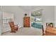 Bedroom featuring a rocking chair, a window, and sliding glass doors leading to screened patio at 4064 River Crest Cir, Leesburg, FL 34748
