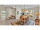 Dining area with wood table and chairs, chandelier, and large window overlooking the yard at 4064 River Crest Cir, Leesburg, FL 34748
