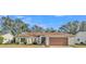 Charming home boasts well-manicured lawn, mature trees, and a welcoming front entrance at 4064 River Crest Cir, Leesburg, FL 34748