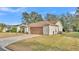 Attached single-Gathering home with a two-car garage and a concrete driveway surrounded by a green lawn at 4064 River Crest Cir, Leesburg, FL 34748
