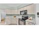 Kitchen featuring sleek black appliances, light countertops and cabinets at 4064 River Crest Cir, Leesburg, FL 34748