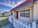 House entrance with red door and white picket fence at 6205 Indian Ln, Lakeland, FL 33813