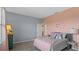 Bedroom with pink and gray color scheme and butterfly wall decor at 3210 Armstrong Ave, Clermont, FL 34714