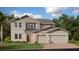 Two-story house with stone accents, three-car garage, and landscaping at 5696 Vinyasa Rd, Clermont, FL 34714