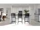 Modern kitchen with white cabinets, island, and black barstools at 5696 Vinyasa Rd, Clermont, FL 34714