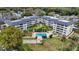 Aerial view of a condo community featuring a pool, shuffleboard, and lush landscaping at 101 N Grandview St # 312, Mount Dora, FL 32757