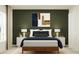 Bedroom with wood bed frame, green accent wall, and modern decor at 2081 Lasso Loop, Eagle Lake, FL 33839