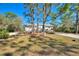 House exterior with two-car garage and mature landscaping at 3060 Granada Dr, Indian Lake Estates, FL 33855