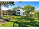 Landscaped backyard with lush grass and a view of the home's exterior at 7006 Arcadian Ct, Mount Dora, FL 32757