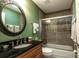 Bathroom with a dark vanity, an oval mirror, and a shower/tub combo at 7006 Arcadian Ct, Mount Dora, FL 32757