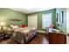 Green-walled bedroom with a queen-size bed, wood floors, and a walk-in closet at 7006 Arcadian Ct, Mount Dora, FL 32757