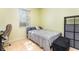 Small bedroom with a light wood floor, a black storage shelf, and a window at 422 W Division St, Clermont, FL 34715