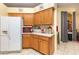 Kitchen area with warm wood cabinets, white refrigerator, and eat-in breakfast area at 422 W Division St, Clermont, FL 34715