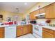 Cozy eat-in kitchen area features warm wood cabinets, white appliances, and a tile floor at 422 W Division St, Clermont, FL 34715
