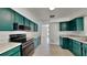 Modern kitchen with teal cabinets, stainless steel appliances, and granite countertops at 6821 Rembrandt Dr, Orlando, FL 32818