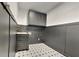 Laundry room with dark gray cabinets and black and white tile floor at 6821 Rembrandt Dr, Orlando, FL 32818