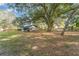 Spacious backyard, partially grassy, with a shed and large oak tree at 820 Lakeshore Dr, Lakeland, FL 33801