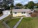 Yellow ranch house with attached garage, fenced yard, hot tub at 228 Azalea St, Lakeland, FL 33803