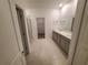 Bright bathroom with double sink vanity, shower, and walk-in closet at 400 Watusi Way, St Cloud, FL 34772