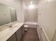 Clean bathroom with tub, vanity, and gray floor tiles at 400 Watusi Way, St Cloud, FL 34772