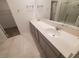 Bright bathroom featuring double vanity with white quartz countertops and large mirror and walk-in shower at 400 Watusi Way, St Cloud, FL 34772