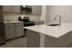 Bright kitchen features stainless steel appliances, gray cabinets, and an island with a stainless steel sink at 400 Watusi Way, St Cloud, FL 34772
