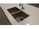 Close up of a double basin stainless steel sink and faucet on a kitchen island with quartz countertops at 400 Watusi Way, St Cloud, FL 34772