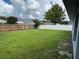 Large grassy backyard with a wooden fence and a view of neighboring houses at 5349 Hidden Oaks Dr, Lakeland, FL 33811