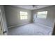 Bedroom with grey walls, carpeting, and two windows at 1650 Pine Ave, Mount Dora, FL 32757