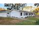 Newly renovated home with a white exterior, black windows, and landscaping at 3720 Willis Rd, Mulberry, FL 33860