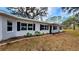 Newly renovated home with a white exterior, black windows, and landscaping at 3720 Willis Rd, Mulberry, FL 33860