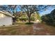 Landscaped front yard with a long driveway and mature oak trees at 3720 Willis Rd, Mulberry, FL 33860