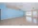 Expansive living room featuring neutral-colored tile flooring, a light blue accent wall, and a ceiling fan at 8779 Fort Socrum Village Way, Lakeland, FL 33810