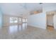 Large, open living room with tile flooring, a ceiling fan, and a glass paneled back door at 8779 Fort Socrum Village Way, Lakeland, FL 33810