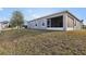 Spacious backyard with lush grass and a screened lanai, perfect for outdoor relaxation and entertaining at 930 Fieldstone Way, Haines City, FL 33844
