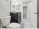 Bathroom featuring a black vanity, sink and toilet with tiled floor at 930 Fieldstone Way, Haines City, FL 33844