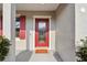 Stylish red front door with glass detailing, complementing the gray exterior at 930 Fieldstone Way, Haines City, FL 33844