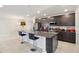 Modern kitchen with a large granite island, stainless steel appliances, and dark cabinetry at 930 Fieldstone Way, Haines City, FL 33844