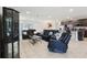 Open-concept living room with dark sofas, tile flooring, and a seamless transition to the modern kitchen at 930 Fieldstone Way, Haines City, FL 33844