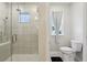 Bathroom featuring a glass-enclosed shower with tiled walls, a window, and a toilet at 930 Fieldstone Way, Haines City, FL 33844