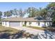 Single-story home with a grey garage door and a paved driveway at 135 Country Club Ln, Mulberry, FL 33860