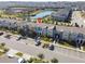 Aerial view of townhomes with parking, a pond, and serene neighborhood at 760 Pebble Beach Dr, Davenport, FL 33896